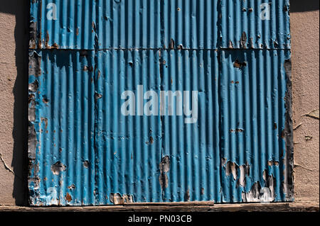 Weathered metal siding rusting along side of building. Stock Photo