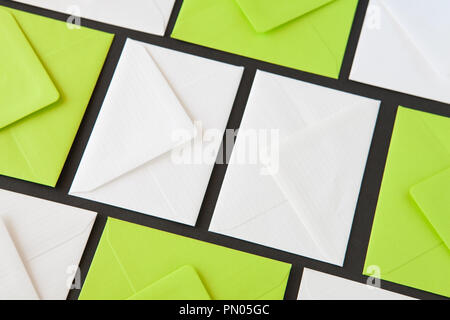 Composition with white and green envelopes on the table. Different colored envelopes on the table. Stock Photo