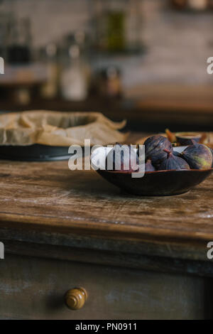 close-up shot of bowl of fresh figs on rustic wooden table Stock Photo