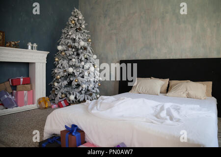 Cozy Bedroom With Christmas Lights And Presents Stock Photo