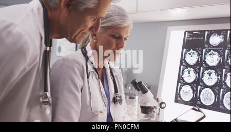Two mature white scientists reading a tablet Stock Photo