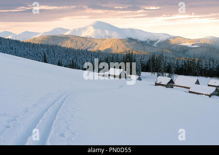 Beautiful pictures of nature in winter. Landscape with mountain huts in the snow. View to the top in the sunset light Stock Photo