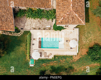 top view of man and woman resting at swimming pool near villa in Italy Stock Photo