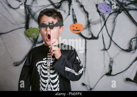 child with a bat covering his eye at halloween party Stock Photo