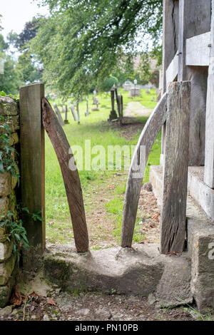 Wooden stile by the lych gate of All Saints church in the village of North Cerney, Gloucestershire, England