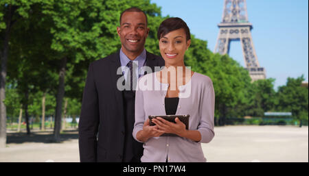 Smiling African-American business professionals with confidence near Eiffel Tower Stock Photo