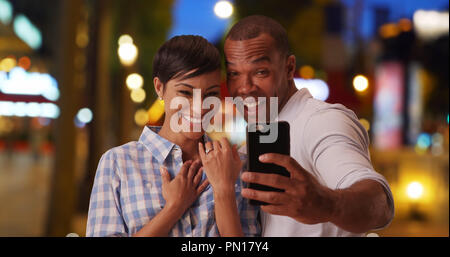 Happy African-American couple announces recent engagement through video chat Stock Photo