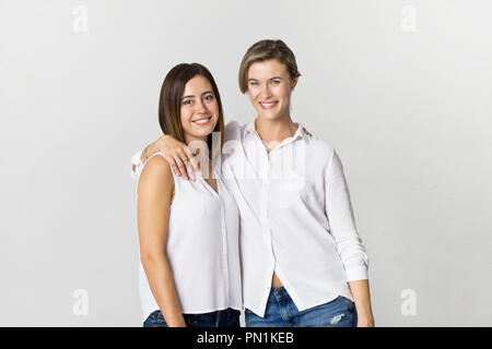 Two girlfriends having fun at studio background. Toothy smile two young women portrait Stock Photo