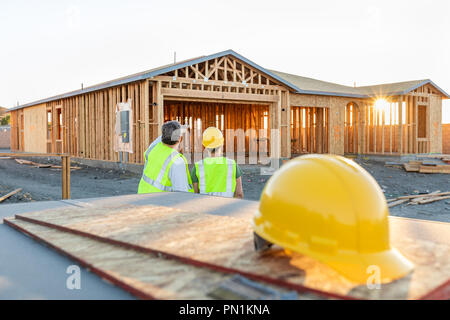 Male and Female Construction Workers at New Home Site. Stock Photo