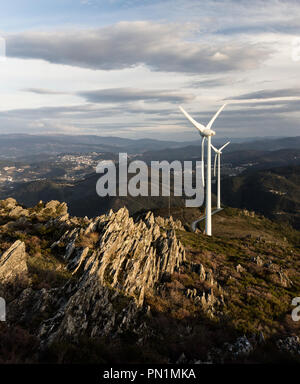 Wind turbines above the rocky hills. Stock Photo
