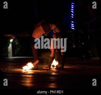 Female fire dancer preforming outdoors at night. Stock Photo