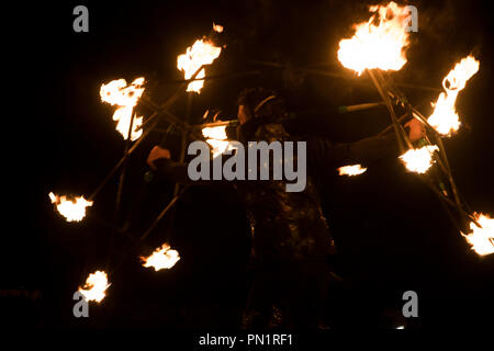 Dancing with fire at night during an outdoor performance. Stock Photo