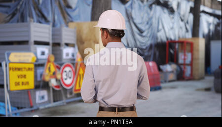 Rear view of attractive and professional contractor using high-tech tablet Stock Photo