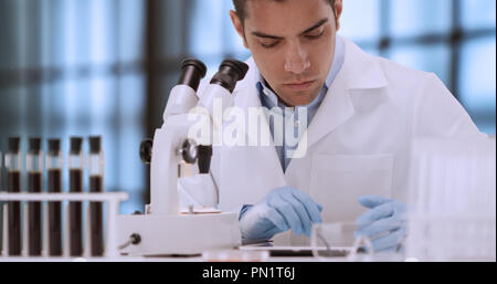 Young Hispanic forensic scientist looking at blood sample through microscope Stock Photo