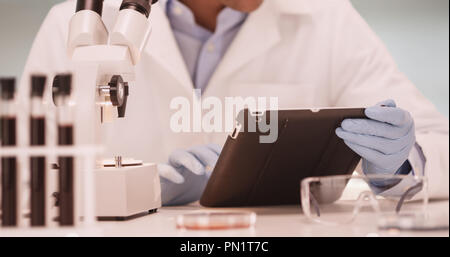 Millennial Latino medical scientist in laboratory using tablet computer Stock Photo