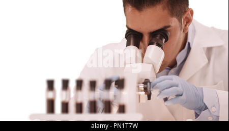 Millennial Latino medical research scientist in lab using microscope Stock Photo