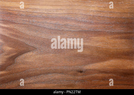 A background of the rich,  brown, figured and textured wood grain of a plank of Walnut. Stock Photo