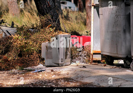 Discard old TV sets on a street, television near the container thrown, the natural environment. A TV thrown out with the garbage. Throwing out garbage Stock Photo