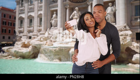 Cute African couple take selfies together in Rome near Trevi Fountain Stock Photo