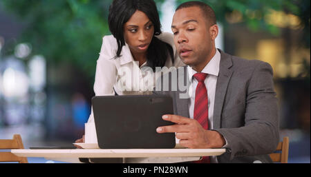 Businessman and woman working together at outdoor cafe Stock Photo