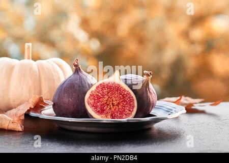 Closeup on fresh figs on dark shiny stone plate outdoors, toned image Stock Photo