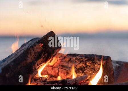 Seaside campfire at sunset close up view with sky. Stock Photo