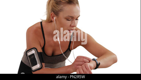 Portrait of white female runner resting and checking watch on white background Stock Photo