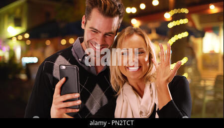 Millennial girlfriend taking selfies with her new engagement ring Stock Photo