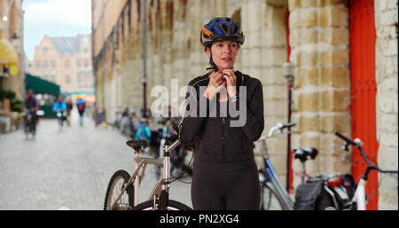 Female bicyclist taking a break from bike riding in Europe Stock Photo
