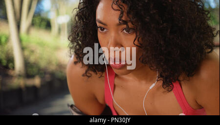 Close-up portrait of exhausted African jogger resting after long daytime jog Stock Photo