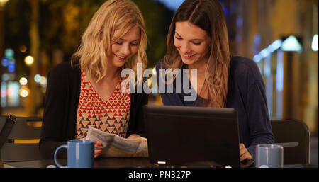Two best friends using travel map in Champs Elysees in Paris France Stock Photo