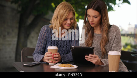 Lovely couple of girls sharing tablet computer in Paris France Stock Photo