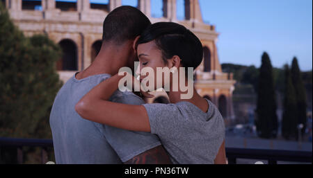 Black boyfriend and girlfriend in Rome chatting in front of the Colosseum Stock Photo