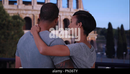 Black boyfriend and girlfriend in Rome chatting in front of the Colosseum Stock Photo