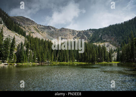 Dark and dramatic sky and clouds over alpine lake and mountain peaks - Nambe Lake in the Santa Fe National Forest in New Mexico Stock Photo