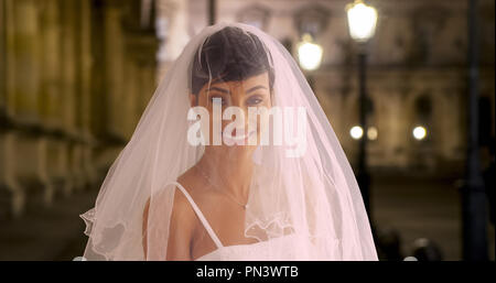 Blushing bride in Paris France at night posing for portrait Stock Photo