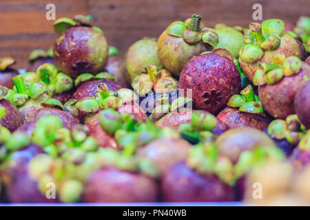 Extra jumbo size of the purple mangosteen (Garcinia mangostana) for sale at the fruit market. Close up texture background surface of organic violet ma Stock Photo