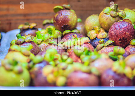 Extra jumbo size of the purple mangosteen (Garcinia mangostana) for sale at the fruit market. Close up texture background surface of organic violet ma Stock Photo