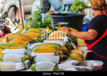 Extra jumbo size of ripe big yellow papaya fruit wrapped in protective net for sale at the fruit market in Bangkok, Thailand. Organic ripe papaya vend Stock Photo