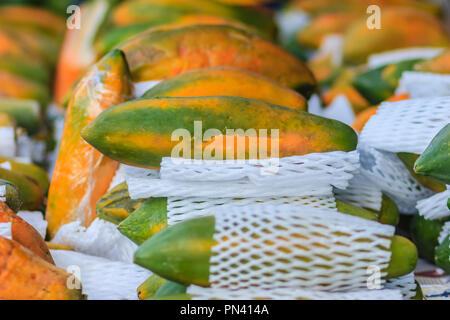 Extra jumbo size of ripe big yellow papaya fruit wrapped in protective net for sale at the fruit market in Bangkok, Thailand. Organic ripe papaya vend Stock Photo