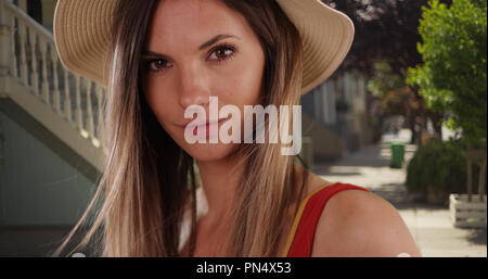 Close-up of stylish hipster girl looking at camera in quiet residential area Stock Photo