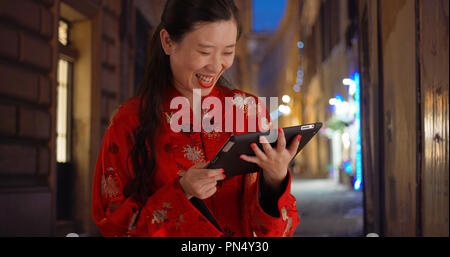Close up of millennial woman smiling and reading tablet device in Florence Italy Stock Photo