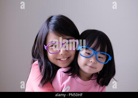 Two little sisters with big eyeglasses Stock Photo