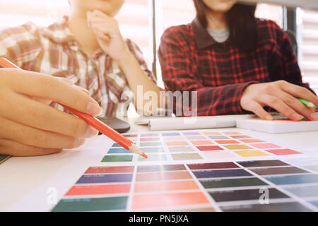 artist meeting with select colour chart paper man and woman discuss on workplace. Stock Photo