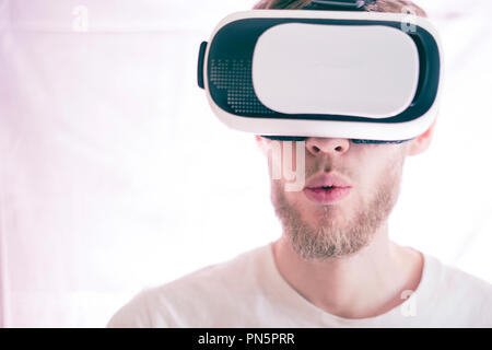 young emotional man using vr glasses playing video virtual games isolated Stock Photo