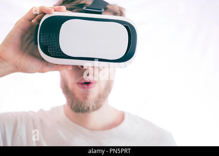 young emotional man using vr glasses playing video virtual games isolated Stock Photo