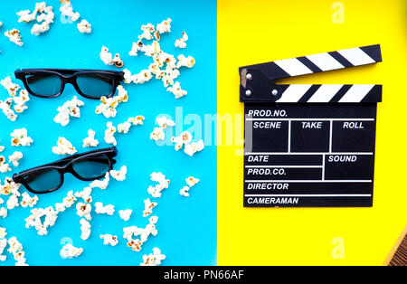 Popcorn and clapperboard on colorful background Stock Photo
