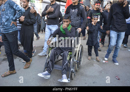 Srinagar, Jammu And Kashmir, Kashmir . 20th Sep, 2018. Kashmiri Shiite Muslim disabled youth sitting on a wheelchair seen taking part in the Muharram procession during the ninth day.Ninth day of Muharram procession in Srinagar, Kashmir. Muslims mourn the slaying of the Prophet Mohammed's grandson Imam Hussain, who was martyred along with his 72 companions in Karbala the city of Iraq in 680 AD. Credit: Masrat Zahra/SOPA Images/ZUMA Wire/Alamy Live News Stock Photo