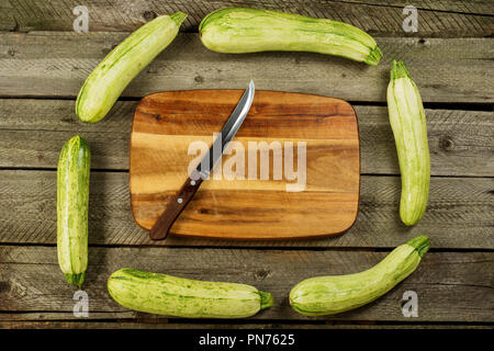 Light green fresh zucchini stacked, farm fresh produce, summer vegetables on rustic background. Top view Stock Photo