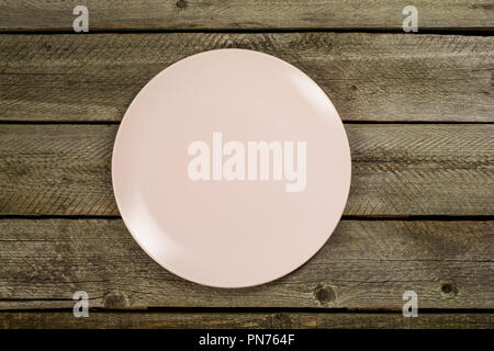 Empty pink plates over wooden table background. View from above with copy space Stock Photo